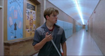 Movie still from “Good Will Hunting” (1997), directed by Gus Van Sant – A young man holding a wrench while standing in a hallway; Medium shot, Low angle