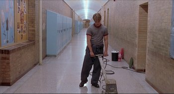 Movie still from “Good Will Hunting” (1997), directed by Gus Van Sant – A man in grey shirt and black pants cleaning a floor; Wide shot, Low angle
