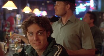 Movie still from “Good Will Hunting” (1997), directed by Gus Van Sant – A young man sitting in front of another man in a cowboy hat; Close Up shot, Over the shoulder angle
