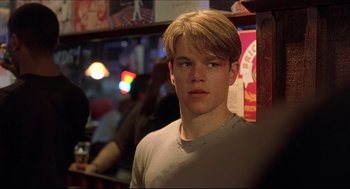 Movie still from “Good Will Hunting” (1997), directed by Gus Van Sant – A young man with blonde hair is standing in front of a bar; Close Up shot, Over the shoulder angle