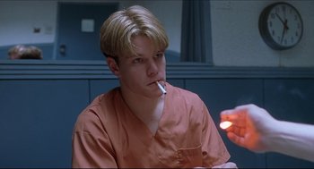 Movie still from “Good Will Hunting” (1997), directed by Gus Van Sant – A man smoking a cigarette in an orange shirt; Close Up shot, Low angle