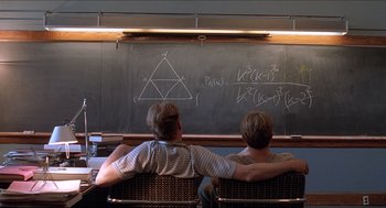 Movie still from “Good Will Hunting” (1997), directed by Gus Van Sant – A couple of men sitting on top of a bench in front of a chalkboard; Medium shot, Over the shoulder angle