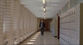 Movie still from “Good Will Hunting” (1997), directed by Gus Van Sant – A man walking down a hallway in a building; Wide shot, Low angle