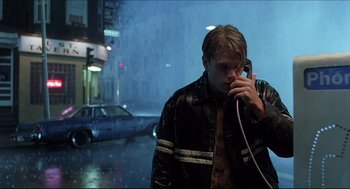 Movie still from “Good Will Hunting” (1997), directed by Gus Van Sant – A man in a leather jacket talking on a phone; Medium shot, Low angle