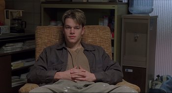Movie still from “Good Will Hunting” (1997), directed by Gus Van Sant – A man sitting in a chair with his hands crossed; Medium shot, Low angle