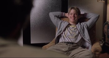 Movie still from “Good Will Hunting” (1997), directed by Gus Van Sant – A man sitting in a chair with his hands behind his head; Medium shot, Low angle