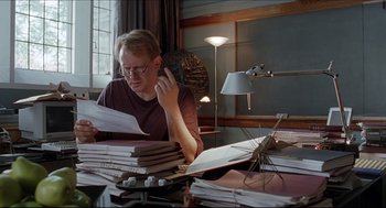 Movie still from “Good Will Hunting” (1997), directed by Gus Van Sant – A man sitting at a table with papers on it; Medium shot, Low angle