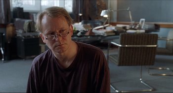 Movie still from “Good Will Hunting” (1997), directed by Gus Van Sant – A man with glasses is sitting in a room; Close Up shot, Over the shoulder angle