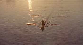 Movie still from “Good Will Hunting” (1997), directed by Gus Van Sant – A person rowing a boat on a body of water at sunset; Extreme Wide shot, High angle