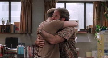 Movie still from “Good Will Hunting” (1997), directed by Gus Van Sant – Two men hugging each other in front of a window; Medium shot, Low angle