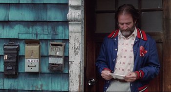 Movie still from “Good Will Hunting” (1997), directed by Gus Van Sant – A man standing in front of a door holding a mail box; Medium shot, Low angle