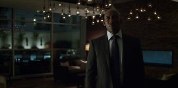 Movie still from “House of Cards” (2013), created by Beau Willimon – A man in a suit and tie standing in front of a window; Medium shot, Low angle