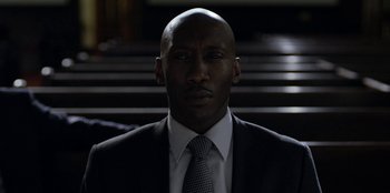 Movie still from “House of Cards” (2013), created by Beau Willimon – A man in a suit and tie in front of stairs; Close Up shot, Low angle