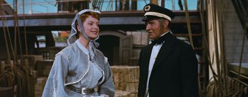 Movie still from “The King and I” (1956), directed by Walter Lang – An older man and a woman standing next to each other in front of a building; Medium shot, Over the shoulder angle