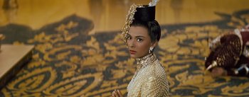 Movie still from “The King and I” (1956), directed by Walter Lang – A woman in a white dress with a hat on top of her head; Close Up shot, Low angle