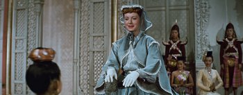 Movie still from “The King and I” (1956), directed by Walter Lang – A woman dressed in a blue dress and white gloves; Medium shot, Low angle