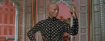 Movie still from “The King and I” (1956), directed by Walter Lang – A bald man wearing a black and silver outfit; Medium shot, Low angle