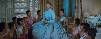 Movie still from “The King and I” (1956), directed by Walter Lang – A woman in a blue dress is standing in front of two other women; Medium shot, Low angle