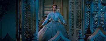 Movie still from “The King and I” (1956), directed by Walter Lang – A woman in a blue dress is standing in front of a door; Medium shot, Low angle