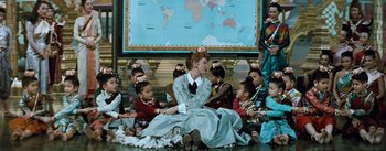 Movie still from “The King and I” (1956), directed by Walter Lang – A group of people sitting on the ground; Wide shot, High angle