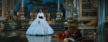 Movie still from “The King and I” (1956), directed by Walter Lang – A man laying on the ground next to a woman in a white dress; Wide shot, High angle