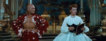 Movie still from “The King and I” (1956), directed by Walter Lang – A man and a woman standing next to each other; Medium shot, Low angle