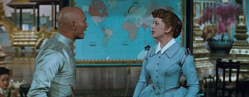 Movie still from “The King and I” (1956), directed by Walter Lang – A woman and a man in front of a world map; Medium shot, Over the shoulder angle