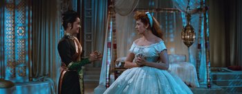 Movie still from “The King and I” (1956), directed by Walter Lang – A woman in a white dress talking to another woman in a white dress; Medium shot, Over the shoulder angle