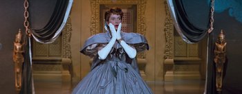 Movie still from “The King and I” (1956), directed by Walter Lang – A woman in a gray dress and white gloves; Medium shot, Low angle