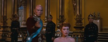 Movie still from “The King and I” (1956), directed by Walter Lang – A man and a woman standing next to each other in a room; Medium shot, Over the shoulder angle