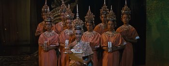 Movie still from “The King and I” (1956), directed by Walter Lang – A group of people dressed up in costumes and holding candles; Medium shot, Low angle