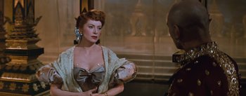 Movie still from “The King and I” (1956), directed by Walter Lang – A woman wearing a dress and a bow in her hair; Medium shot, Over the shoulder angle