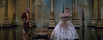 Movie still from “The King and I” (1956), directed by Walter Lang – A woman in a ball gown standing in front of a chandelier; Wide shot, Low angle