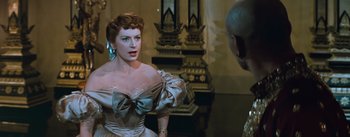 Movie still from “The King and I” (1956), directed by Walter Lang – A woman wearing a dress with a big bow on it; Medium shot, Over the shoulder angle