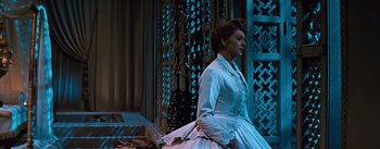 Movie still from “The King and I” (1956), directed by Walter Lang – A woman in a white dress sitting in a room; Medium shot, Low angle
