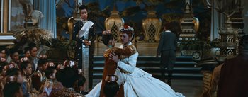 Movie still from “The King and I” (1956), directed by Walter Lang – A couple of people that are dancing in a room; Wide shot, Over the shoulder angle