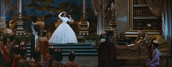 Movie still from “The King and I” (1956), directed by Walter Lang – A woman in a white dress on a stage; Wide shot, Low angle