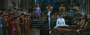 Movie still from “The King and I” (1956), directed by Walter Lang – A group of people standing in front of a stage; Wide shot, High angle
