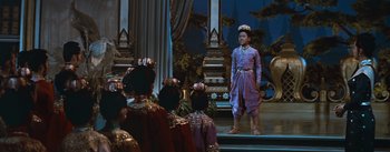 Movie still from “The King and I” (1956), directed by Walter Lang – A man standing in front of a group of people; Wide shot, High angle