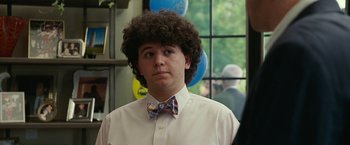 Movie still from “The King of Staten Island” (2020), directed by Judd Apatow – A young man with curly brown hair wearing a plaid bow tie; Close Up shot, Over the shoulder angle