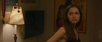 Movie still from “The King of Staten Island” (2020), directed by Judd Apatow – A woman standing in front of a tv in front of a painting; Close Up shot, Over the shoulder angle