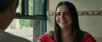 Movie still from “The King of Staten Island” (2020), directed by Judd Apatow – A woman smiling for the camera in front of a window; Close Up shot, Over the shoulder angle
