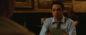 Movie still from “The King of Staten Island” (2020), directed by Judd Apatow – A man wearing a neck tie holding a plate; Close Up shot, Over the shoulder angle