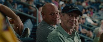 Movie still from “The King of Staten Island” (2020), directed by Judd Apatow – A couple of men sitting next to each other in front of a crowd; Close Up shot, Over the shoulder angle