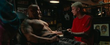 Movie still from “The King of Staten Island” (2020), directed by Judd Apatow – A man sitting next to another man in a tattoo shop; Medium shot, Low angle