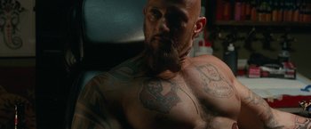 Movie still from “The King of Staten Island” (2020), directed by Judd Apatow – A man with a beard and tattoos on his chest; Close Up shot, Low angle