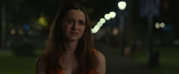 Movie still from “The King of Staten Island” (2020), directed by Judd Apatow – A woman in an orange top is standing in the dark; Close Up shot, Over the shoulder angle