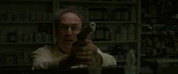 Movie still from “The King of Staten Island” (2020), directed by Judd Apatow – A man holding a gun in a room filled with bottles; Close Up shot, Low angle