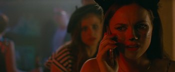 Movie still from “The King of Staten Island” (2020), directed by Judd Apatow – A woman on a cell phone with another woman in the background; Close Up shot, Over the shoulder angle