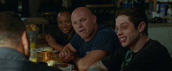Movie still from “The King of Staten Island” (2020), directed by Judd Apatow – A group of people sitting at a table eating food; Medium shot, Over the shoulder angle